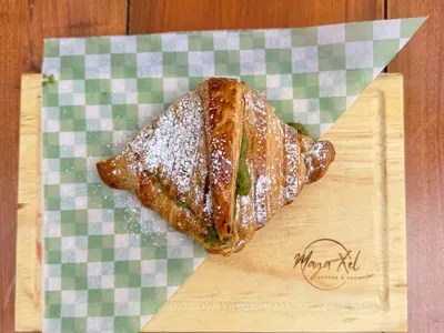 Croissant relleno de pistache con azúcar glass en Maya Xel